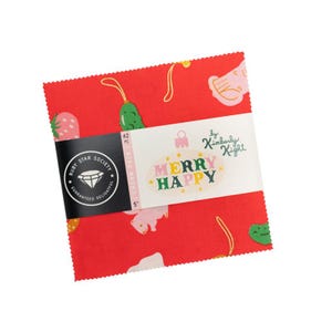 May include: A stack of 5-inch red fabric squares with a festive pattern of cartoon fruits and vegetables. The fabric is wrapped with a label that reads "MERRY HAPPY" and "Ruby Star Society".