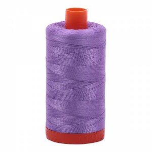 May include: A spool of purple thread with an orange plastic bobbin.