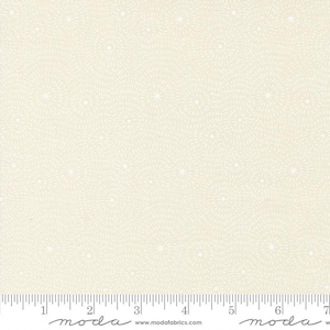 May include: Cream-colored fabric with a repeating pattern of white starburst designs. The fabric has a ruler along the bottom edge, marked in inches. The word "moda" is printed on the ruler.