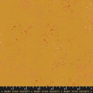 May include: A yellow fabric with a speckled pattern of small red and pink dots.