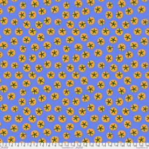 May include: A blue fabric with a repeating pattern of orange circles, each containing a green star-like design. The fabric has a ruler along the bottom edge, with measurements in inches.