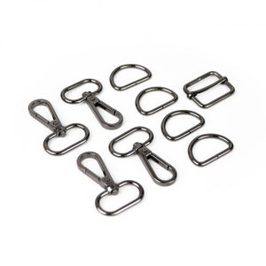 May include: A set of eight black metal hardware pieces for crafting, including D-rings, swivel clasps, and a buckle.