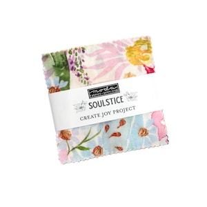May include: A stack of floral fabric squares wrapped with a white band. The fabric features watercolor-style designs with pink, blue, and yellow flowers. The band reads "SOULSTICE CREATE JOY PROJECT".