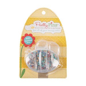 May include: A package of "Pretty Pins" applique pins by Lori Holt. The package has a yellow gingham pattern and a clear plastic container shaped like a bee holding 250 pins with colorful heads. Text on the package reads "for all of your sewing needs!"