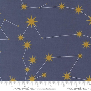 May include: Dark blue fabric with a constellation pattern. Gold-colored star shapes are connected by white lines, creating celestial designs. The fabric has a textured appearance, suitable for quilting or crafting projects.