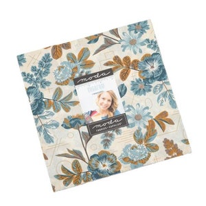 May include: A fabric fat quarter bundle featuring a floral pattern with blue, brown, and white colors. The fabric is from the "Garden Girl" collection by Moda Fabrics.