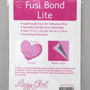 May include: A package of Fusi Bond Lite iron-on adhesive web. The package is white with pink text and graphics. The text includes "Fusi Bond Lite", "Lightweight Iron-On Adhesive Web", and "Size: 17 in x 1.25 yds".