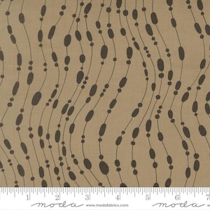 May include: Tan fabric with a repeating pattern of dark brown, elongated ovals and small circles connected by thin, wavy lines. The fabric has a textured appearance and a ruler is visible along the bottom edge.
