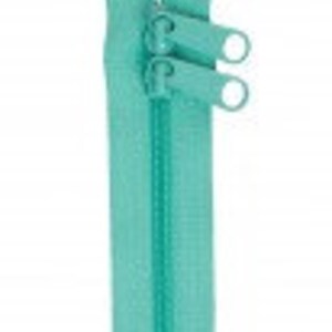 May include: A turquoise zipper with two metal sliders. The zipper is closed and has a smooth finish.
