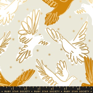 May include: A beige fabric with a repeating pattern of white and gold doves flying against a background of gold stars. The fabric is from Ruby Star Society.