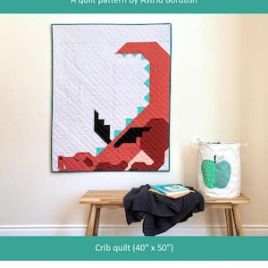 May include: A rectangular crib quilt measuring 40 inches by 50 inches featuring a geometric red dragon design with black wings and teal accents on a white background. The text Dragon Dreams A quilt pattern by Astrid Bordush is visible.