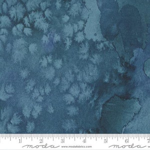 May include: A fabric with a watercolor-like design in shades of blue. The pattern features irregular shapes and textures, with lighter areas resembling floral or cloud-like formations. The fabric has a mottled appearance, with darker areas creating depth and contrast.