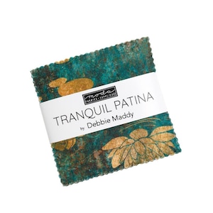May include: A square stack of fabric squares with pinked edges, featuring a teal and dark green mottled background with gold floral patterns. A white paper band wraps around the center, printed with the text Moda Fabrics Supplies, TRANQUIL PATINA by Debbie Maddy.