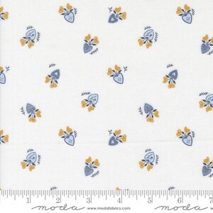 May include: White fabric with a repeating pattern of blue hearts and yellow flowers. The hearts have a stitched design, and the flowers are clustered together. The fabric has a ruler along the bottom edge.