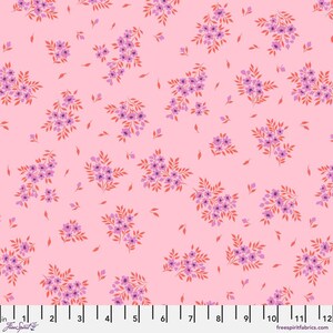 May include: Pink fabric with a repeating pattern of small purple and orange floral clusters and scattered leaves. The fabric has a light pink background and a ruler along the bottom edge. The text "freespiritfabrics.com" is visible.