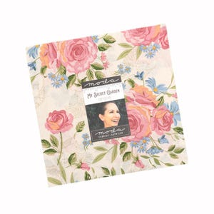 May include: A square stack of fabric squares featuring a cream background with a floral pattern of pink roses, green leaves, and small blue flowers. A central label reads "moda", "MY SECRET GARDEN", "STACY IEST HSU", and "moda FABRICS + SUPPLIES".
