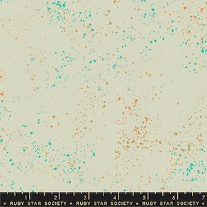 May include: A beige fabric with a speckled pattern of small orange, yellow, and teal dots.