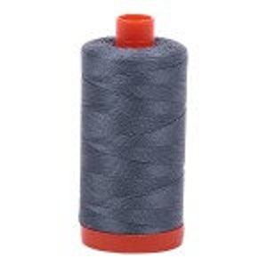 May include: A spool of gray sewing thread with an orange plastic bobbin.