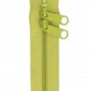May include: A lime green zipper with two gold sliders and two gold rings.