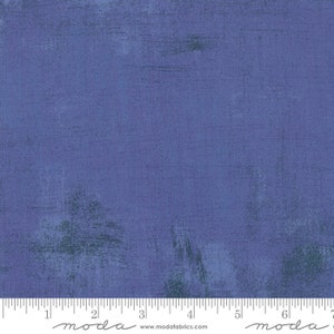 May include: A solid blue fabric with a subtle textured pattern. The fabric has a slightly distressed look with faded areas and brushstrokes. The fabric is marked with a ruler and the word "moda" in a handwritten font.