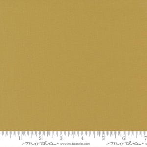 May include: A solid piece of fabric in a mustard yellow color. The fabric has a subtle texture and is shown with a ruler for scale.