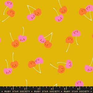 May include: Mustard yellow fabric with a repeating pattern of cartoon cherries. The cherries are pink and orange with white stems and smiling faces. The text "RUBY STAR SOCIETY" is at the bottom.