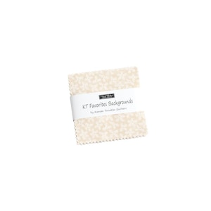 May include: A cream-colored fabric square with a white floral pattern. The fabric has a label that reads "KT Favorites Backgrounds by Kansas Troubles Quilters".