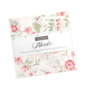May include: A stack of fabric squares with a floral pattern in pink, red, and green on a white background. The fabric is labeled "Abide" by Moda Fabrics. A ruler is placed across the fabric squares, with measurements in inches.