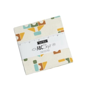 May include: A fabric square with a white background and a colorful geometric pattern of yellow, orange, green, and blue. The fabric square has a label that says "Moda Fabrics Supplies" and "ABC...xyz" with the name "Stacy Test Hsu" below.