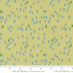 May include: A yellow fabric with a repeating pattern of blue and green dots. The fabric is measured with a ruler in inches.