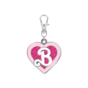 May include: Pink heart-shaped keychain with a silver clip and a white letter B in the center. The heart has a pink glitter finish.