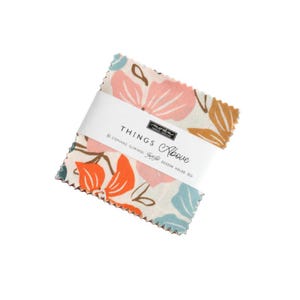 May include: A fabric square with a floral pattern in shades of pink, orange, blue, and brown. The fabric is labeled "Things Above" by Moda Fabrics.