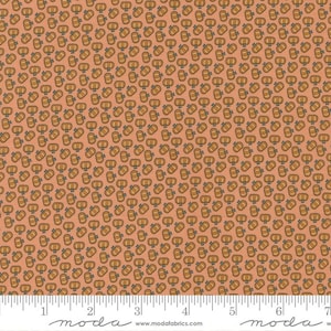 May include: A peach-colored fabric with a repeating pattern of small brown pumpkins. The fabric is shown with a ruler, indicating it is 44 inches wide.