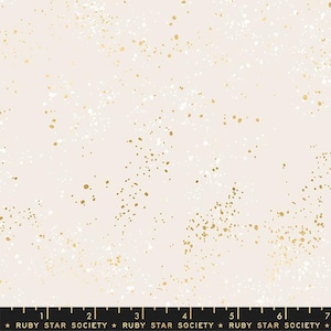 May include: A white fabric with a subtle speckled pattern of gold and white dots. The fabric has a soft, delicate feel and is perfect for crafting projects.