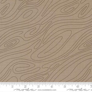 May include: Tan fabric with a wood grain pattern. The fabric has a light brown background with darker brown, swirling lines resembling the growth rings of a tree. A ruler is at the bottom of the fabric.