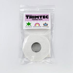 Puede incluir: Un rollo blanco de cinta Thimtec Thimble Tape en una bolsa de plástico transparente. La cinta es resistente a las perforaciones, colorida y cómoda. Está diseñada para proteger tus uñas.