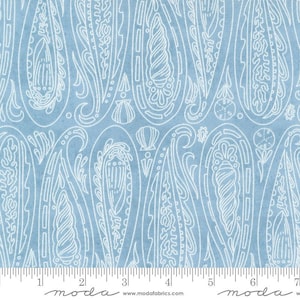 May include: A blue fabric with a white paisley pattern. The pattern features seashells and other ocean-inspired designs. The fabric is marked with a ruler in inches.