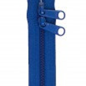 May include: A blue zipper with two pull tabs. The zipper is closed and has a smooth finish.
