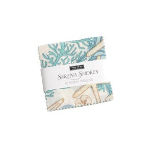 May include: A fabric square with a white background and a blue and brown coral and seashell pattern. The fabric square has a label that reads "Serena Shores by Robin Pickens".