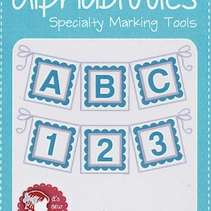 May include: A set of blue and gray alphabet and number stencils for marking fabric. The stencils are shaped like banners with scalloped edges. The text on the image reads "Alphabitties Specialty Marking Tools" and "Package contains 26 letters and 10 numbers!"
