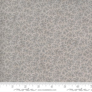 May include: A beige fabric with a repeating pattern of small, dark gray, stylized branches. The fabric is measured with a ruler that reads "moda" at the 2-inch and 6-inch marks.