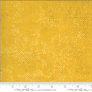 May include: Yellow fabric with a white and green speckled pattern. The fabric is from the Moda Fabrics line.