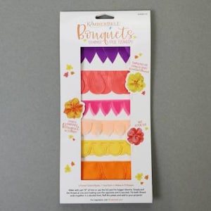 May include: A package of Kimberbell Bouquets, featuring colorful fabric strips in shades of purple, orange, pink, peach, yellow, and orange. The package includes the text "Kimberbell Bouquets" and instructions for use.