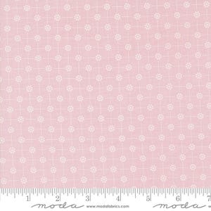 May include: Pink fabric with a white repeating pattern of small circles. The fabric has a subtle grid pattern and the text "moda" is printed at the bottom of the image.