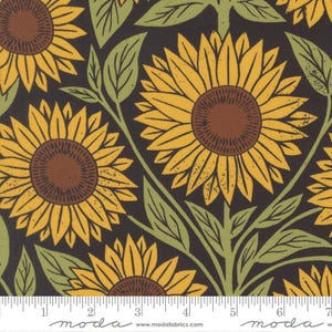 May include: Fabric with a repeating pattern of sunflowers in yellow, brown, and green on a dark background. The sunflowers have detailed petals and brown centers. Green leaves and stems are also visible. The fabric has a ruler along the bottom with the word "moda" printed on it.