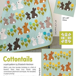 May include: A light blue quilt with a repeating pattern of bunnies and flowers. The bunnies are in various colors, including brown, white, and gray. The flowers are yellow, pink, and blue. The quilt is 67" x 73". The image also shows a pillow and a smaller quilt.