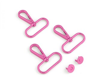 May include: Three pink metal swivel clasps and two pink metal snap fasteners. The clasps have a rectangular loop and a hook.