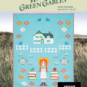May include: A quilt pattern featuring a blue and white house with a red roof, a girl in a red dress, and a fence. The quilt is surrounded by a green border and has the text "Anne of Green Gables" and "Quilt Pattern" on it. The quilt is 58 1/2 inches by 76 1/4 inches.