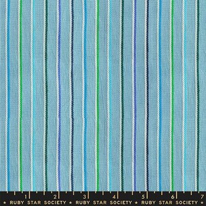 May include: Light blue fabric with vertical stripes in various shades of blue, green, and white. The fabric has a textured appearance. The bottom of the image shows a ruler with the text "RUBY STAR SOCIETY".