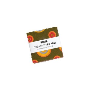 May include: A green fabric square with a pattern of orange, yellow, and blue circles. The fabric square has a white label that reads "CREATIVITY ROARS! by Creativity Shell".